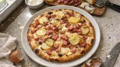 Pizza paysanne maison : crème fraîche, pommes de terre et bacon, bien gratinée